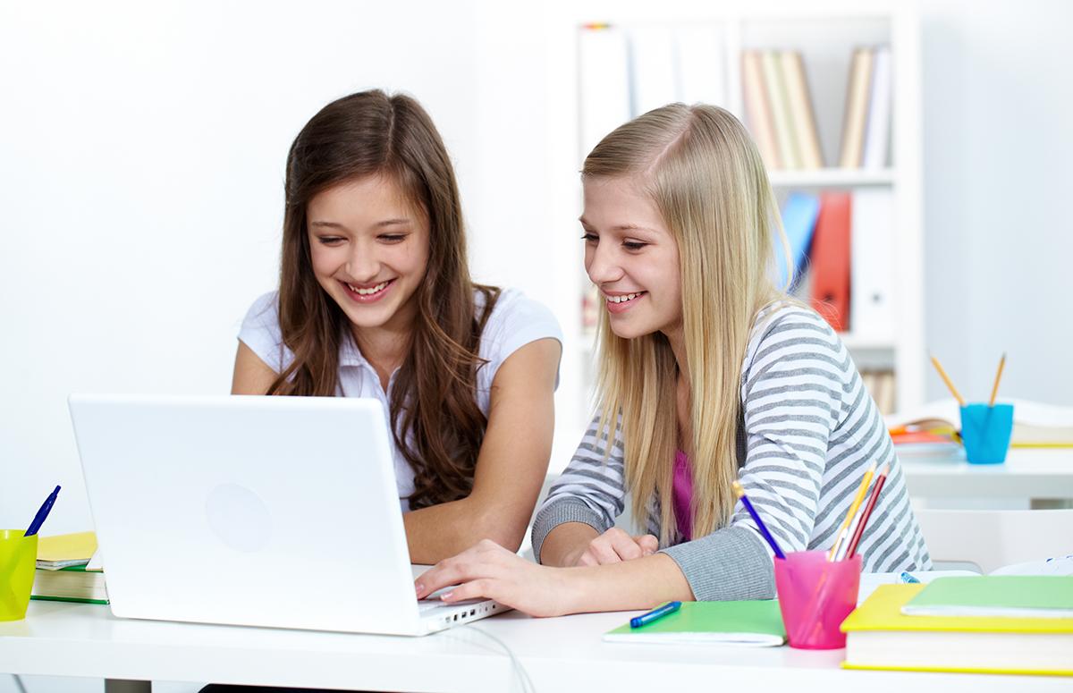 Zwei Jugendliche arbeiten an einem Laptop